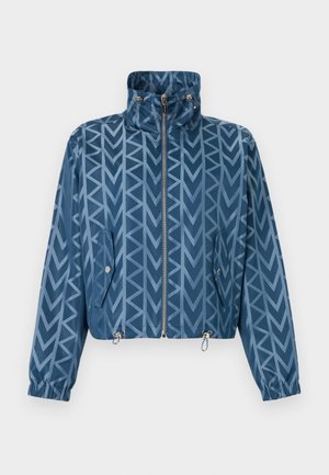 Veste zippée bleue avec col montant, motif géométrique en forme de flèches, poches à rabat boutonnées, poignets élastiques et cordons de serrage ajustables à l'ourlet.