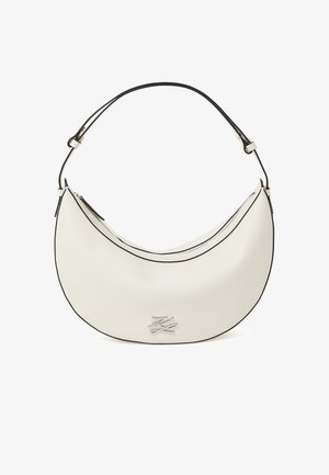 Hvid halvmåneformet lædertaske med sort kant, justerbar skulderrem, lynlåslukning og sølvfarvet metallogo på forsiden.