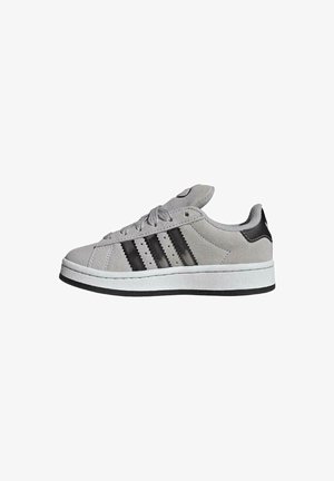 Zapatilla de ante gris con rayas negras, suela de goma blanca y cuello acolchado, mostrada en perfil lateral mirando hacia la izquierda.