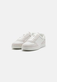 Weiße Sneakers mit einer Kombination aus strukturiertem Wildleder und glattem Leder, ausgestattet mit perforierten Details, Schnürdesign und flacher Gummisohle.