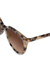 Solskenformade solglasögon i sköldpaddsdesign med brynlinje, gradientbruna linser, genomskinliga bågar och guldaccenter. Varumärket på skalmen.