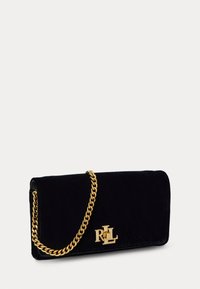 Fekete bársony clutch arany lánc pánttal és arany logó kiegészítővel. Sleek, téglalap alakú formája és sima textúrája van.