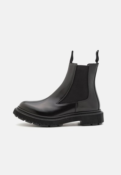 Black leather Chelsea boots with elastic side panels, rubber sole, chunky ridged outsole, and pull tabs for easy wear.