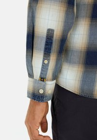 Kariertes Hemd in Blau, Beige und Weiß mit knöpfbarem Ärmelsaum und kleinen Logotab. Weicher Stoff mit lockerer Passform und ausgeprägtem Karomuster.