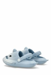 Sandalias de plástico azul claro con punta redondeada, correa ajustable y un diseño juguetón de tiburón en los lados. Suela texturizada para mayor agarre.