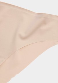 Nude naadloze bikini onderkant gemaakt van gladde, rekbare stof met een gebogen snit en nette randen, met subtiele textuur en geen zichtbare hardware.