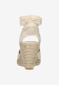 Crème espadrille wedge sandalen met geweven bovenkant, verstelbare enkelband en gevlochten jute zool. Heeft een gestructureerde afwerking.