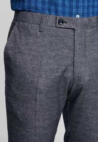 Gray wool-blend trousers with a flat front, side pockets, and a single button closure. Textured fabric with subtle pattern details.