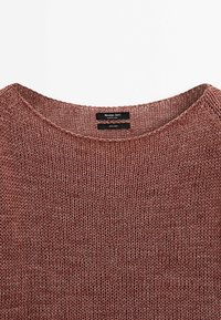 Pull en lin marron tricoté avec un col rond et une étiquette noire indiquant la marque Massimo Dutti et les détails du tissu.