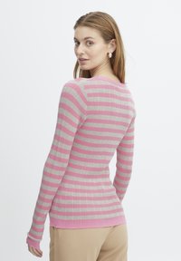 Randig tröja i ljusrosa och grått, ribbat material, figurnära design med långa ärmar och rundad halsringning. Har ribbade ärmslut och nederkant i rosa.
