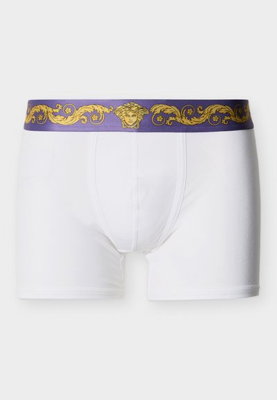 Caleçons boxer pour hommes blancs avec une ceinture violette ornée d'un motif doré ornemental et d'un emblème de tête de Méduse.