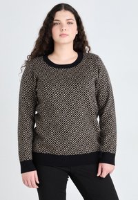 Sweter dzianinowy w geometryczny wzór w kolorze czarnym i beżowym. Posiada okrągły dekolt oraz prążkowane mankiety i dół, zestawiony z czarnymi spodniami.