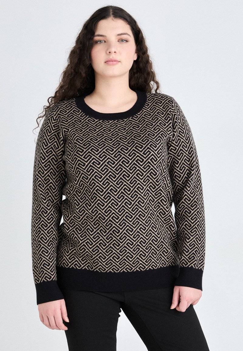 Sweter dzianinowy w geometryczny wzór w kolorze czarnym i beżowym. Posiada okrągły dekolt oraz prążkowane mankiety i dół, zestawiony z czarnymi spodniami.