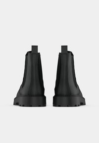 Μαύρες ankle μπότες με λείο δερμάτινο επάνω μέρος, ελαστικές πλευρικές πάνελ και υφή από καουτσούκ στη σόλα. Διαθέτουν θηλιές στο πίσω μέρος για εύκολη φόρεση.