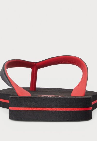 Black flip-flop sandals with a red strap and accent. Thick sole with a texture pattern and a red stripe detail on the side.