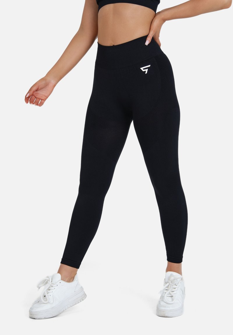 Hochtaillierte schwarze Leggings aus dehnbarem Stoff; mit einem Logo am Bund und einer geschwungenen Nahtgestaltung für eine figurbetonte Optik.