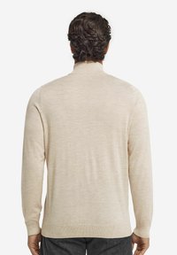 Helle beige Pullover mit hochgeschlossenem Kragen, langen Ärmeln und glatter Textur. Verfügt über einen gerippten Saum und Bündchen für eine enge Passform.