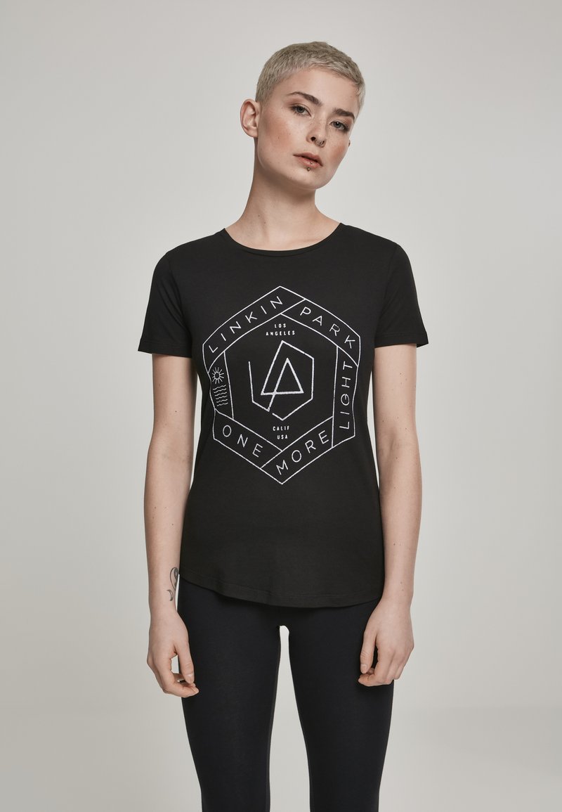Sort kortærmet t-shirt med et hvidt grafisk design, der har geometriske elementer og tekst, lavet af blødt, strækbart bomuldsstof.
