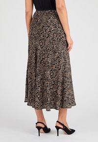 Gonna nera midi con motivo a stampa leopardata beige. Tessuto fluido con una leggera lucentezza, dotata di una vita elasticizzata e pieghe a strati.