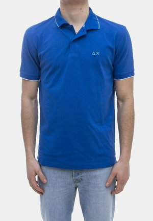 Polo blu realizzata in cotone, con colletto con bordatura a contrasto, maniche corte e un piccolo logo geometrico sul lato sinistro del petto.