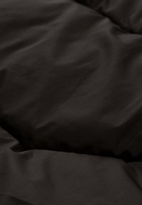 Zwart gewatteerd fabric met een soepele textuur, gekenmerkt door een zachte, matte afwerking en subtiele rimpels, wat duidt op padding en warmte.