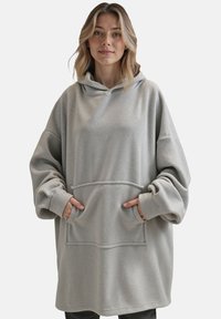 Felpa oversize grigia chiara in tessuto morbido. Caratterizzata da una grande tasca frontale e un cappuccio con cordino regolabile. Senza patter. 