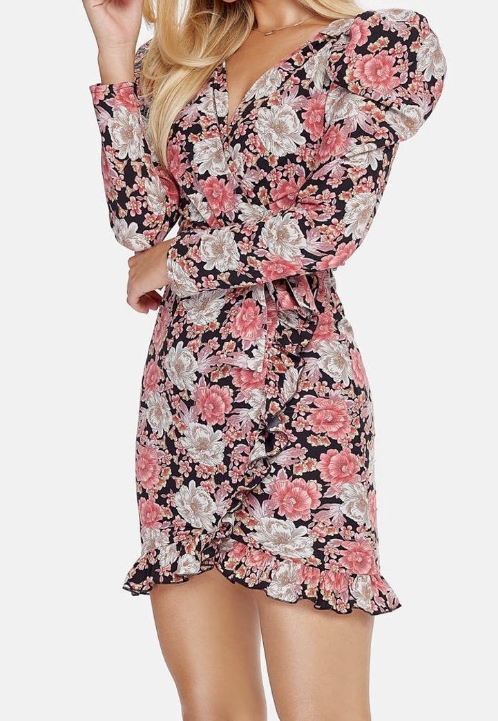 Robe portefeuille fleurie avec manches longues bouffantes, base noire, grandes fleurs roses et blanches, ourlet à volants et détail de ceinture à la taille.