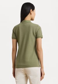 Polo olive avec manches courtes, col et texture douce. La vue arrière montre une coupe ajustée et de subtils détails de couture.