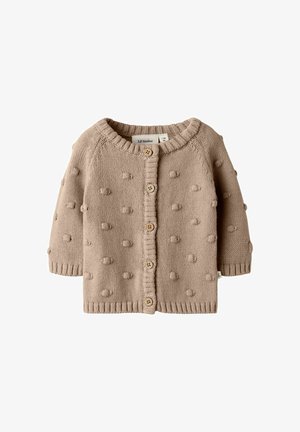 Gilet pour bébé en tricot beige, avec col rond, boutons en bois sur le devant et motif en tricot avec pompons texturés.