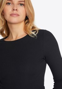 Zwart geribbeld langemouwen top met een ronde halslijn, met een gladde textuur en een aansluitend ontwerp dat een slanke silhoeët benadrukt.