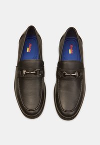 Schwarze Lederloafer mit glatter Textur, abgerundeter Spitze, dekorativem Riemen mit metallischen Beschlägen und blauen Einlegesohlen mit Markenlogo.