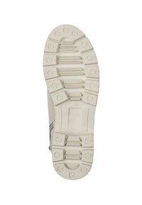 Semelle de chaussure en caoutchouc blanche avec un motif de grip texturé et des clous circulaires. Présente un petit indicateur de taille en relief "37".