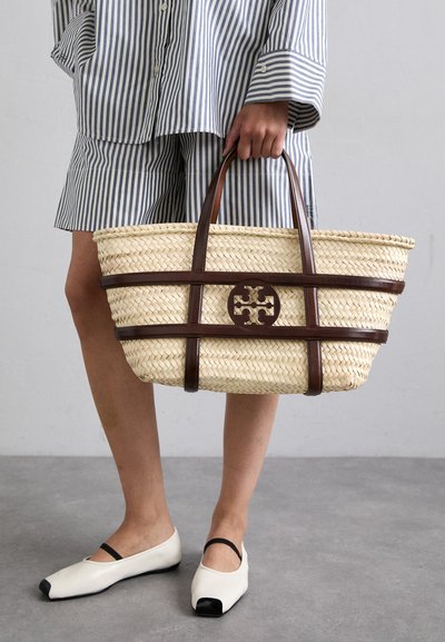 Borsa tote in paglia intrecciata con accenti e manici in pelle marrone. Presenta un logo intagliato e bande orizzontali di contrasto.
