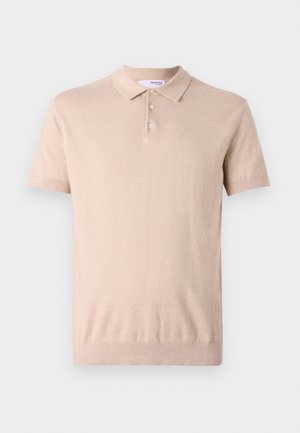 Polo beige à manches courtes en tissu tricot doux ; comporte un col classique, une patte de boutonnage à trois boutons, ainsi que des poignets et un ourlet côtelés.