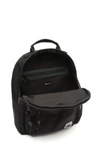 Černý batoh kulatého tvaru, se zipovým uzávěrem, vnitřní kapsou a měkkou texturou látky. Má malé logo a madlo na nošení.