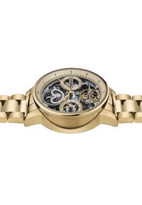 Montre squelette dorée avec un cadran transparent montrant des engrenages complexes, un bracelet noir et doré, et un design à deux sous-cadrans.