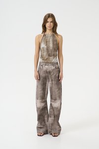 Top a fascia marrone e beige a fantasia abbinato a pantaloni grigi a gamba larga. Entrambi i capi presentano un tessuto morbido con una superficie liscia.