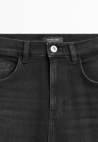 Jeans neri in denim con chiusura anteriore a bottoni, design classico a cinque tasche e un'etichetta con la scritta "Massimo Dutti" sulla vita.