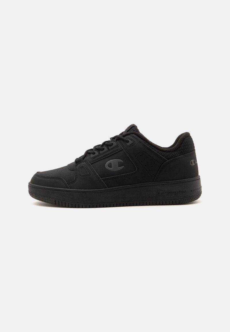 Μαύρο sneaker χαμηλού ύψους με κορδόνια μπροστά, επενδεδυμένο γιακά και πλευρικό λογότυπο σε λείες και υφασμάτινες επιφάνειες πάνω σε λευκό απλό φόντο.