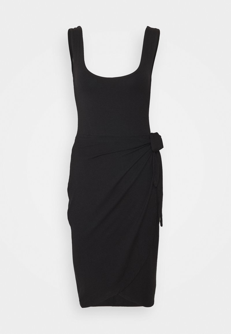 Robe noire sans manches jusqu'au genou avec encolure carrée et détail drapé noué à la taille sur un fond clair uni.