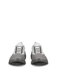 Par rjavih in belih športnih copatov z zavezovanjem čipk in debelim črnim podplatom, pogled od spredaj na belem ozadju.