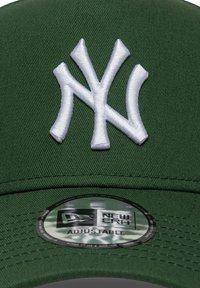 Πράσινο υφασμάτινο καπέλο μπέιζμπολ με λευκό κεντητό λογότυπο NY μπροστά. Περιλαμβάνει κυκλικό ετικέτα που υποδεικνύει ρυθμιζόμενο μέγεθος.