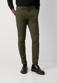 Donkergroene slim-fit broek van een gladde stof met een subtiele glans, met twee voorkruiszakken en een knoopsluiting in de taille.