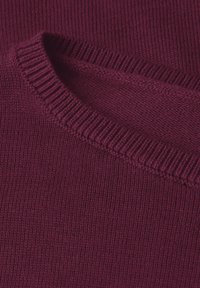 Bordeaux gebreide trui met geribde halslijn en manchetten, voorzien van een gladde textuur en een close-up van de weving van de stof.