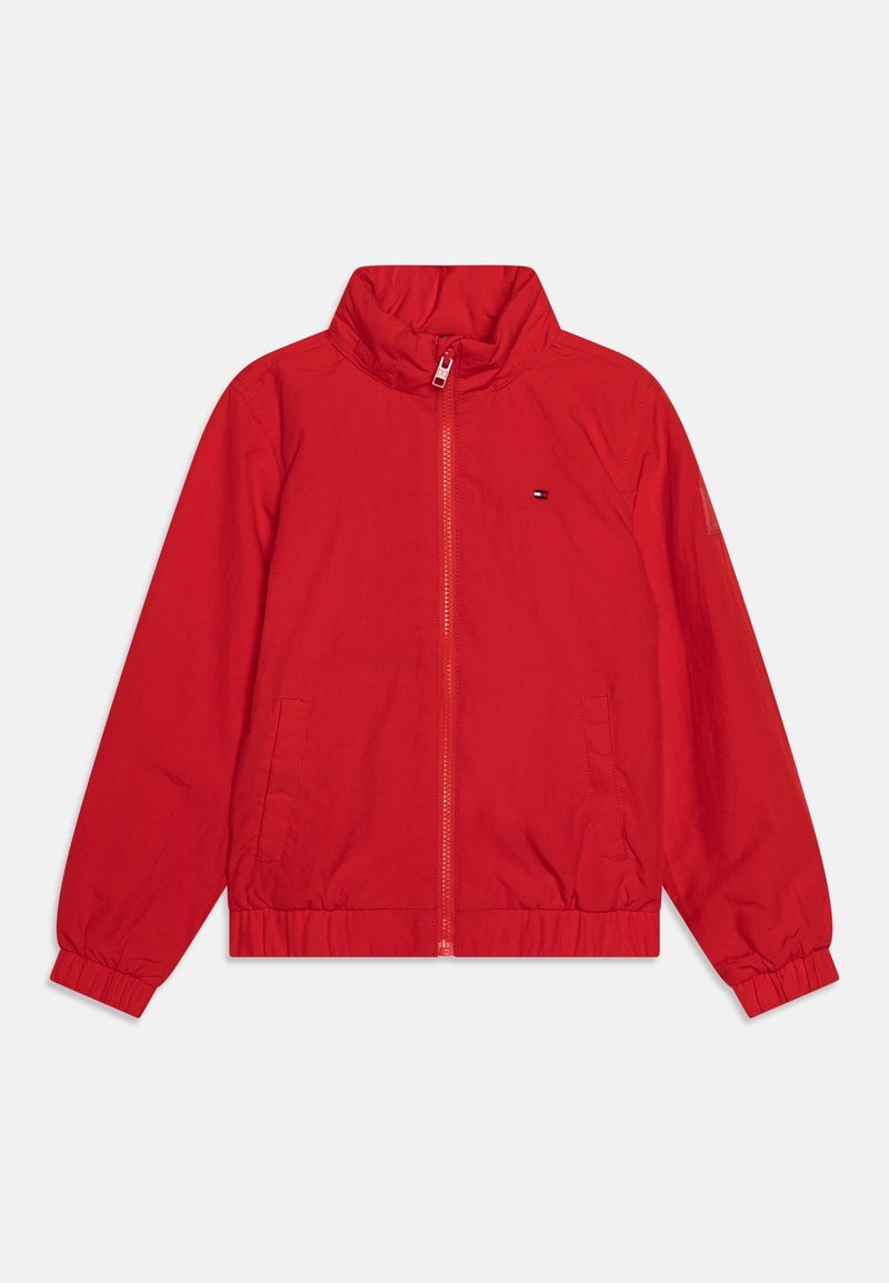 Chaqueta roja con cremallera, cuello alto, puños y dobladillo elásticos, con un pequeño logo en el pecho. Tela suave y ligera.