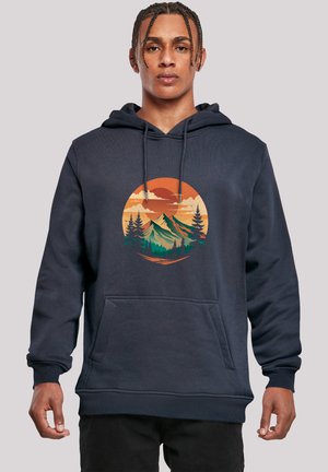 Navyblaues Hoodie aus Baumwollmischung mit einer Kängurutasche. Es verfügt über eine Grafik von Bergen und Bäumen in einem kreisförmigen Design in Orange und Grün.