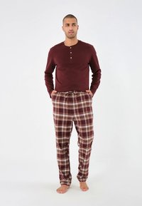 Chemise manches longues couleur bordeaux avec patte de boutonnage à trois boutons et pantalon de pyjama à carreaux marron. Tissu doux, coupe décontractée et détail de ceinture élastique.