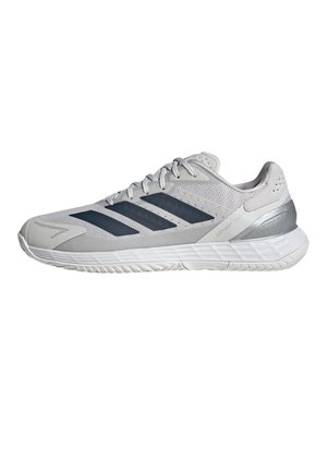 Hellgrauer Sportschuh mit dunkelgrauen Streifen, Mesh-Obermaterial, weißer Sohle und metallischer Fersenstütze, seitlich gezeigt.