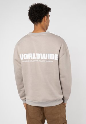 Hellgrauer Pullover mit dem Wort "WORLDWIDE" in fetten weißen Buchstaben auf dem Rücken. Mit Rundhalsausschnitt und gerippten Bündchen.