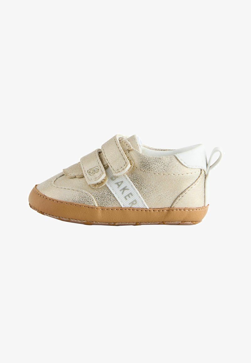 Chaussure beige pour tout-petit avec dessus texturé, deux brides en Velcro, accents blancs et semelle en caoutchouc marron clair. Dispose d'une languette arrière pour un enfilage facile.